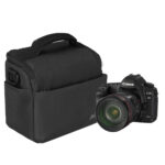 Dulepro Companion Shoulder Bag S18 zwart zijaanzicht naast DSLR-camera op witte achtergrond
