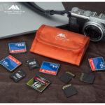 Summit-Creative Memory Card Bag orange liggend op tafel met openliggende SD- en CF-geheugenkaarten
