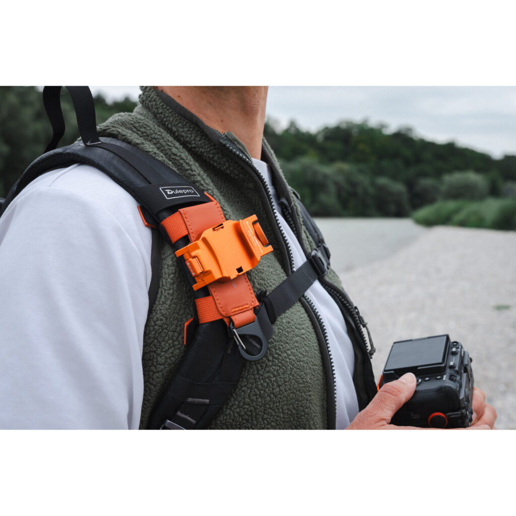 Summit-Creative Speedyclip Orange gemonteerd op rugzakschouderband in gebruik buitenshuis
