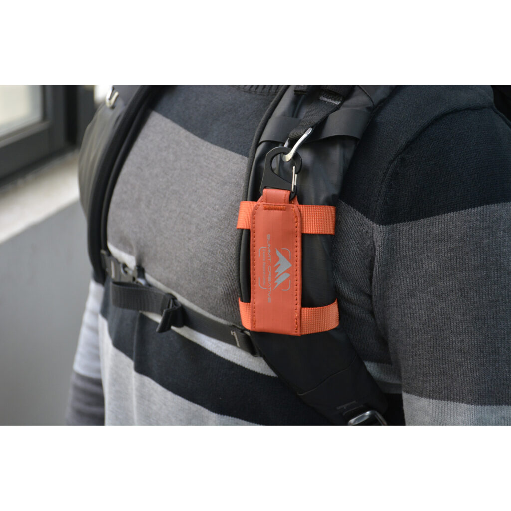 Summit-Creative Speedyclip-riem oranje bevestigd aan borstband van grijs vest met Speedyclip-houder