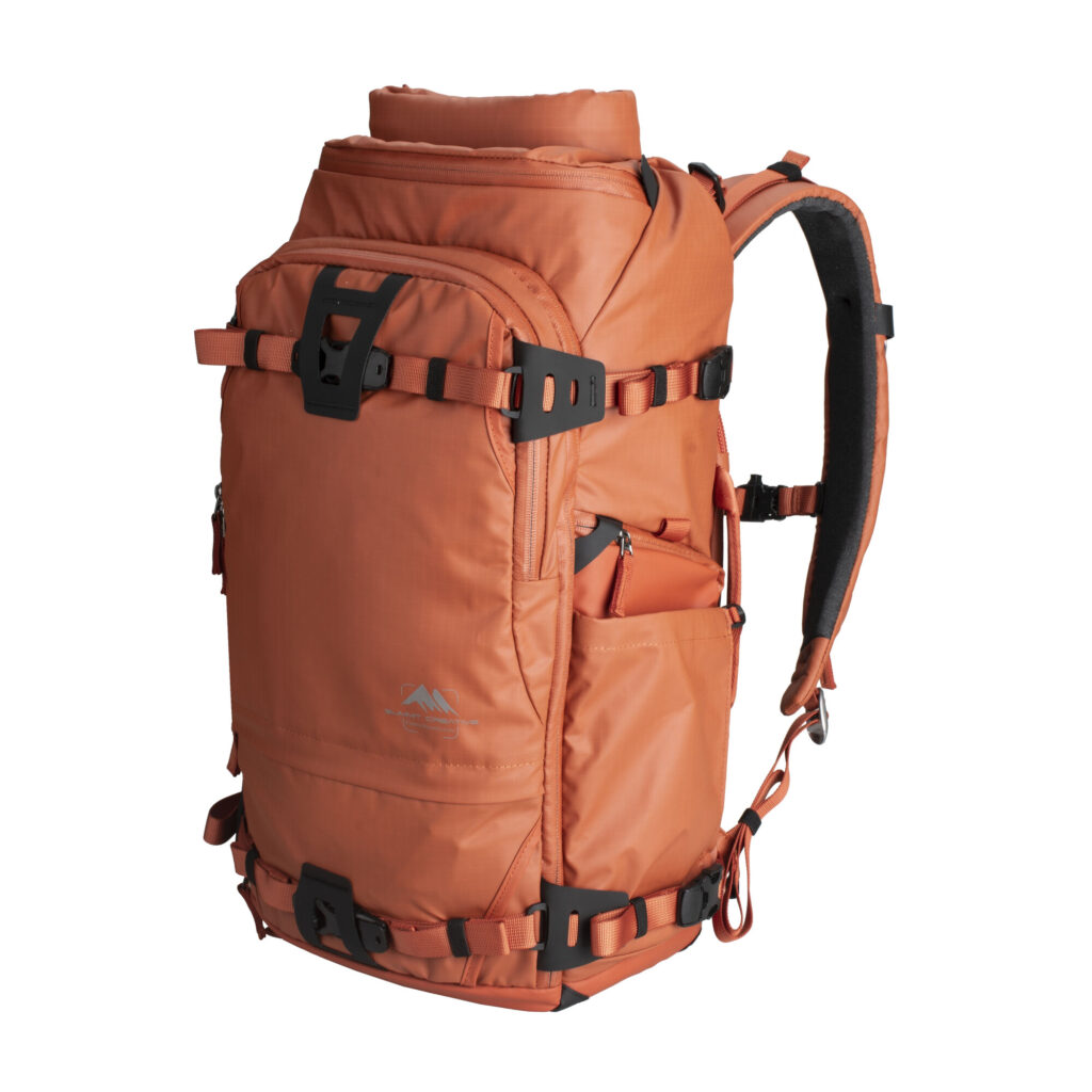 Summit-Creative Tenzing Backpack oranje zijaanzicht met gesloten rolltop-vak en bevestigingslussen