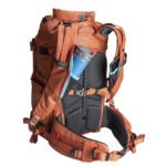 Summit-Creative Tenzing Backpack oranje achteraanzicht gedragen met cameratoegang via zijkant