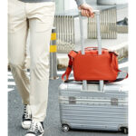 Summit-Creative Tenzing Shoulder Bag oranje gebruikt op trolleyhandvat tijdens het reizen