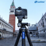 Leofoto GW-01 Statief-gearhead met camera op statief langs rivierpromenade gericht op historische gevels.