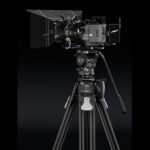 Leofoto FH-20M Videokop studioweergave op statief met grote videocamera en accessoires op zwarte achtergrond.
