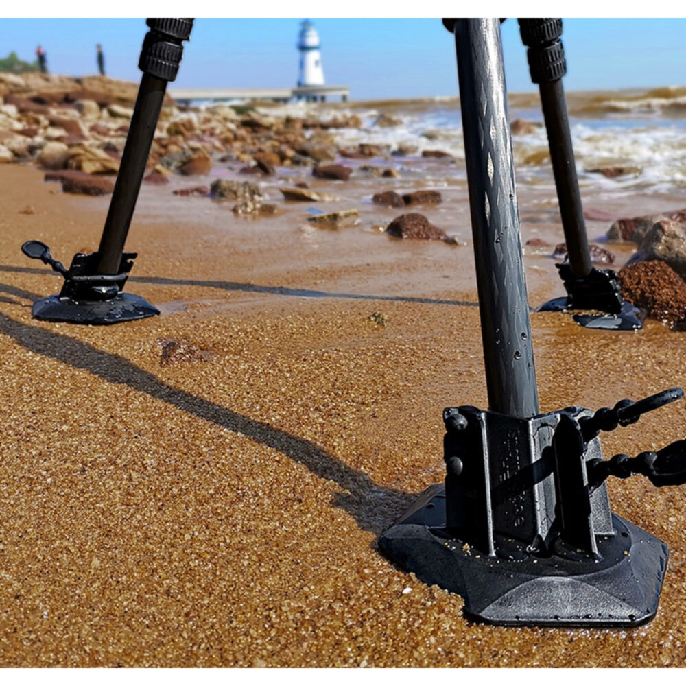 Leofoto TFW-2 statiefvoet grote rubberen schotels drie statiefpoten stabiel opgesteld op een zandstrand.