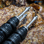 Leofoto-Tripod-pad-Long-spikes-with-rubber-caps-TFS-S1-4-7 Leofoto S1/4 statiefvoet twee statiefpoten met lange spikes die stabiel op een rotsachtig terrein rusten.