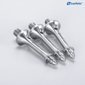 Leofoto S3/8 statiefvoet lange spikes gemonteerd onder zwarte statiefpoten op natte rotsen.