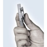 Leofoto PC-60 smartphonehouder klein en licht tussen vingers gehouden om het compacte zakformaat te tonen.