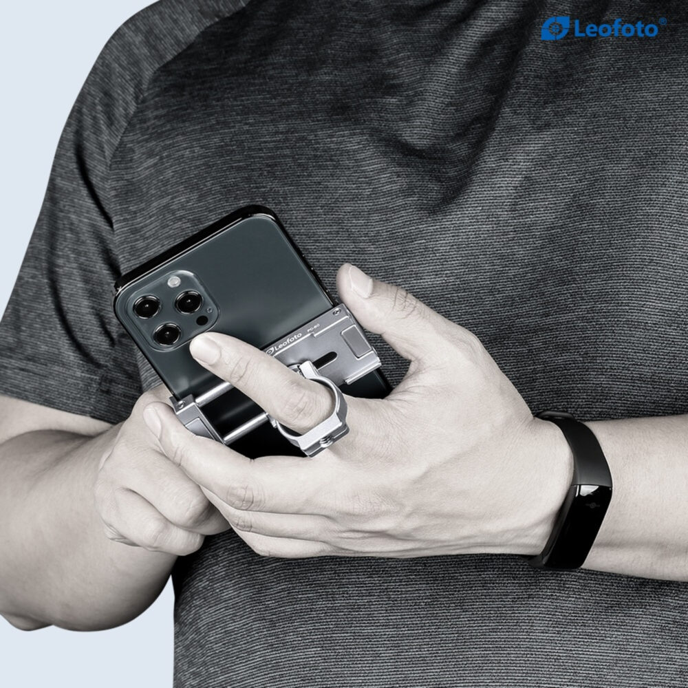 Leofoto PC-60 smartphonehouder gebruikt als vingergrip achter op smartphone terwijl iemand het toestel stevig vasthoudt.