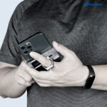 Leofoto PC-60 smartphonehouder gebruikt als vingergrip achter op smartphone terwijl iemand het toestel stevig vasthoudt.