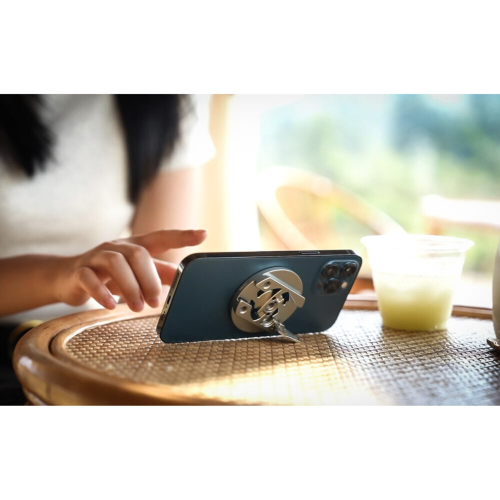Leofoto PM-01 smartphonehouder ondersteunt smartphone liggend op tafel als standaard tijdens het kijken van video.