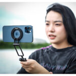 Leofoto PS-5 Smartphonehouder in gebruik waarbij een vrouw buiten een smartphone magnetisch horizontaal vasthoudt als cameragrip.