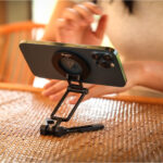 Leofoto PS-5 Smartphonehouder gebruikt als tafelstandaard met smartphone horizontaal op tafel tijdens een videogesprek.