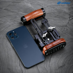 Leofoto PH-01 smartphone-videorig opgevouwen rig met houten grepen naast een smartphone op donkere ondergrond.