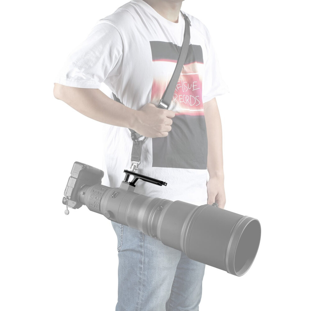 Leofoto NF-06 objectiefvoet in gebruik waarbij een Nikon Z supertelelens met draagriem veilig aan de voet wordt gedragen.