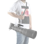 Leofoto NF-06 objectiefvoet in gebruik waarbij een Nikon Z supertelelens met draagriem veilig aan de voet wordt gedragen.