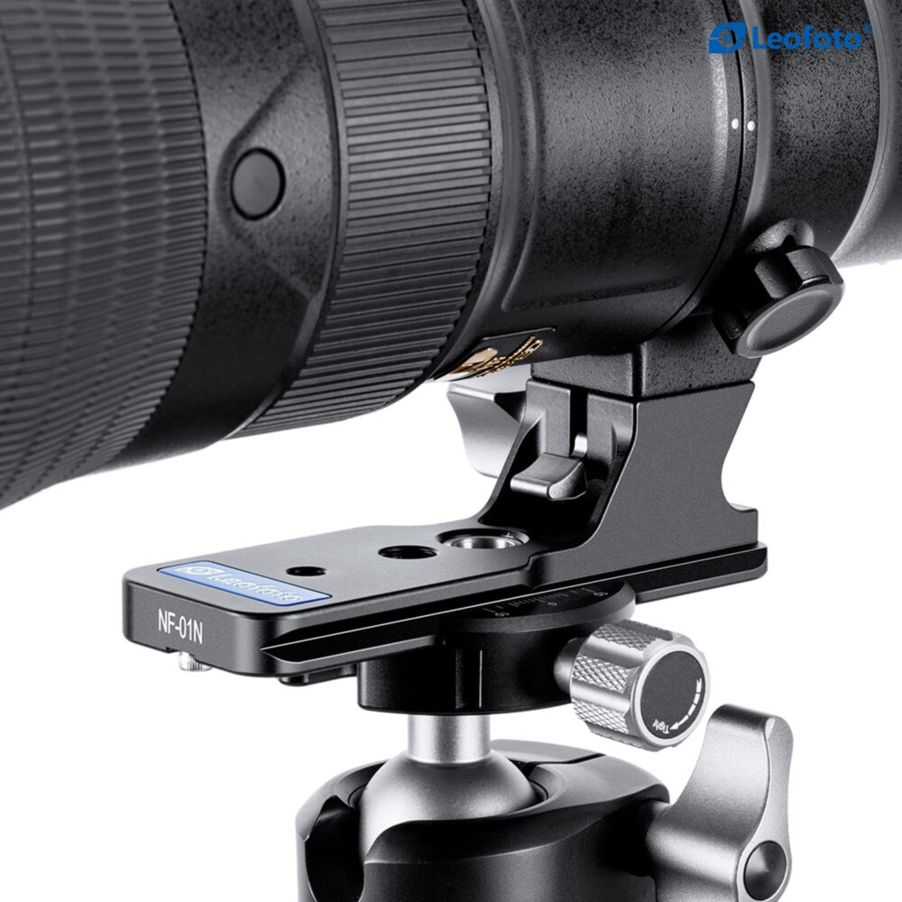 Leofoto NF‑01N objectiefvoet met grote Nikon telelens op lange statiefplaat geplaatst voor stabiele ondersteuning.