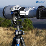 Leofoto MPG-2 Gimbal-uitbreiding in gebruik met camera en witte telelens op statief in open landschap.