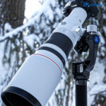 Leofoto MPG-2 Gimbal-uitbreiding met grote telelens en camera op statief tijdens winterse vogelfotografie in de sneeuw.