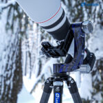 Leofoto PG-3 2-weg kantelkop met zware telelens gemonteerd op statief in besneeuwd buitenlandschap.