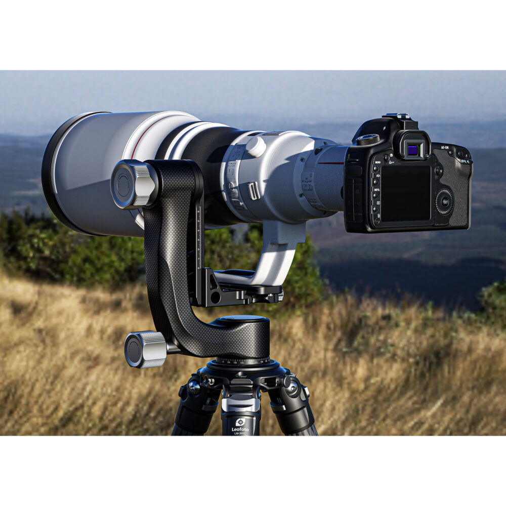 Leofoto PG-3 2-weg kantelkop in gebruik met camera en witte supertelelens op statief in heuvelachtig graslandschap.