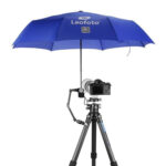 Leofoto UC-02 buisklem in gebruik op statief met gemonteerde magic arm en paraplu die camera tegen regen beschermt.