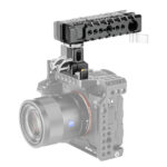 Leofoto AH-1 cameracage handgreep bovenop een camera cage gemonteerd op systeemcamera, schuin vooraanzicht.