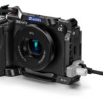 Leofoto ZV-E1 cameracage Sony ZV-E1 met aangesloten kabel en geïntegreerde kabelbescherming bij de aansluitpoorten.