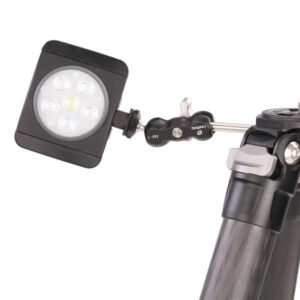 Leofoto AM-1 scharnierende arm gemonteerd op statief met bevestigde LED-lamp voor extra verlichting.