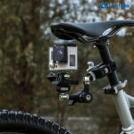 Leofoto AM-5 Scharnierende Arm bevestigd aan reling met GoPro actioncam in buitenomgeving.