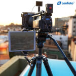 Leofoto AM-5 Scharnierende Arm in gebruik op statief met camera en groot extern beeldscherm.