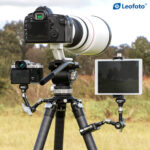 Leofoto AM-5 scharnierende arm praktijkvoorbeeld op statief met camera, telelens en gemonteerde monitor.