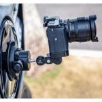 Leofoto SC-02 Statief Kit zuignap met magic arm en systeemcamera bevestigd aan autovelg voor dynamische opnames.