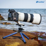 Leofoto MT-02C+LH-22 Tafelstatief blauw in gebruik met camera en telelens op ondergrond buiten.