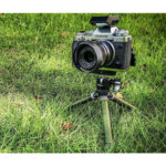 Leofoto MT-02C+LH-22 Tafelstatief olijfgroen in gebruik op gras met camera gemonteerd.