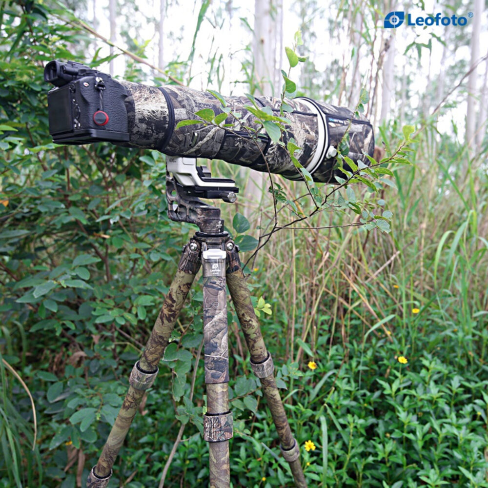Leofoto LS-365C Tripod full camouflage met telelens en camera opgesteld in dicht groen.