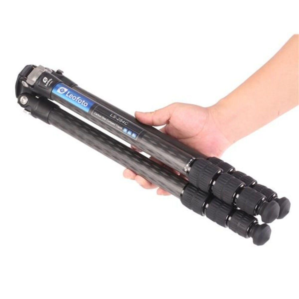 Leofoto LS-284C Tripod compact ingeklapt in een hand om het draagbare formaat te tonen.