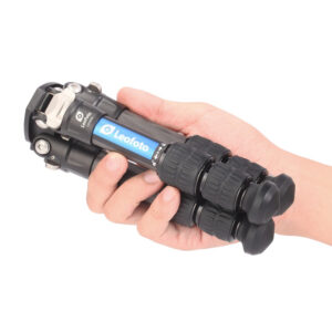 Leofoto LS-223C Tripod ingeklapt in hand, toont ultracompact formaat en lichte constructie.