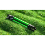 Leofoto LY-265CF Tripod compact opgevouwen liggend op gras met groene carbon poten.