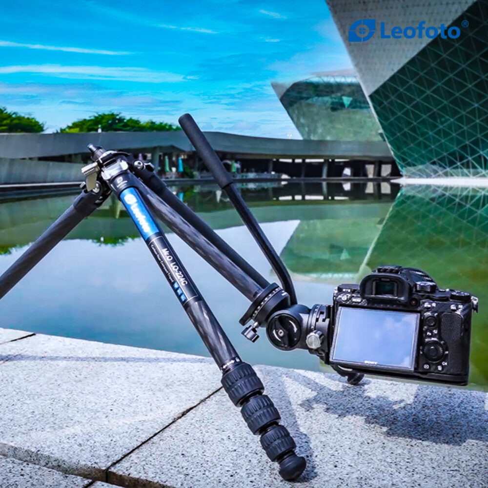Leofoto LO-224C Tripod laag opgesteld bij een vijver met systeemcamera gemonteerd voor creatieve perspectieven.