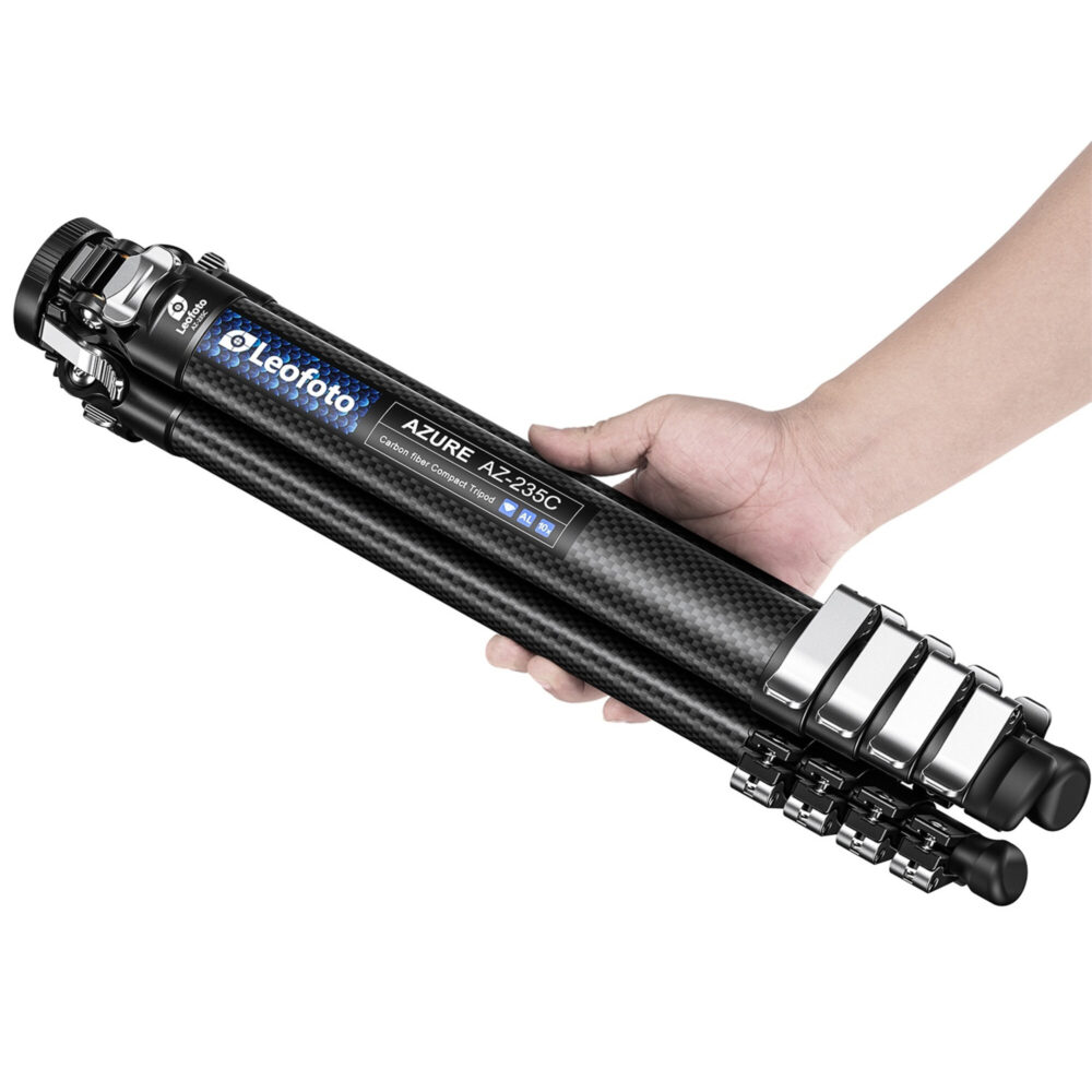 Leofoto AZ-235C Tripod opgevouwen in een hand om het compacte reisformaat te tonen